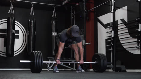 Hombre-Musculoso-Haciendo-Levantamientos-Pesados-Con-Peso-Pesado-En-Un-Gimnasio-Oscuro