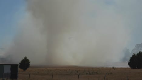 Helicopter-disappearing-behind-thick-bush-fire-smoke-and-re-appearing-again