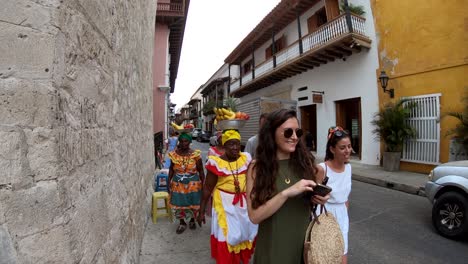 Tourists-are-walking-next-to-a-group-of-palenqueras-in-Cartagena
