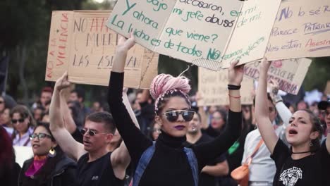 Mujeres-Y-Hombres-Protestando-Pacíficamente,-Marchando-Y-Cantando-Canciones-Contra-La-Desigualdad,-Marchas-A-Favor-De-Los-Derechos-De-Las-Mujeres-Con-Mensajes-Escritos-En-Tableros.