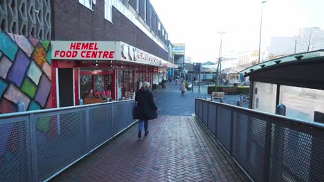 A-woman-running-down-a-ramp,-in-a-hurry,-in-Hemel-Hempstead-Town-Centre