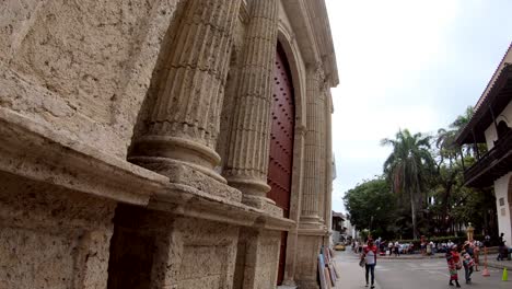 An-old-building-with-columns-and-a-huge-red-and-brown-door-in-the-old-town-of-Cartagena-de-Indias,-Colombia