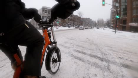 Zeitraffer-Seitenwinkelperspektive-Eines-Kuriers-Auf-Einem-E-Bike,-Der-Durch-Winterliche-Straßen-In-Der-Innenstadt-Von-Montreal-Fährt