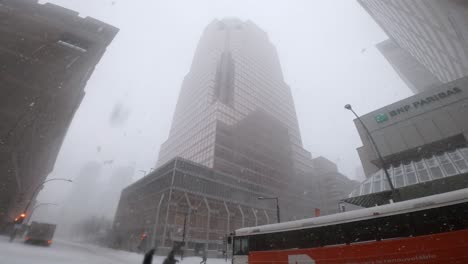 Family-Walking-Across-Union-Avenue-During-Heavy-Snowfall-With-Pan-Up-Reveal-Of-KPMG-Tower-In-Downtown-Montreal