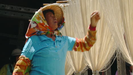 Trabajador-De-Una-Fábrica-En-China-Revisando-Estantes-De-Fideos-Crudos-Colgados-Para-Secar-Bajo-La-Cálida-Luz-Del-Sol-De-La-Tarde