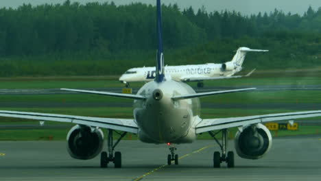 Rückansicht-Eines-Skandinavischen-Flugzeugs,-Das-Mit-Einem-Polnischen-Flugzeug-Im-Hintergrund-Rollt