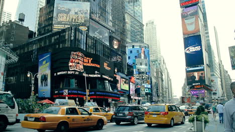 Gelbe-Taxis-Und-Menschen,-Die-Morgens-Auf-Einem-überfüllten-Time-Square-Spazieren-Gehen