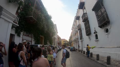 Un-Guía-Turístico-Sosteniendo-Un-Paraguas-Amarillo-Guía-A-Un-Grupo-De-Turistas-Por-Las-Calles-De-Cartagena-De-Indias,-Colombia