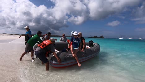 Ein-Tourist-Steigt-Aus-Dem-Boot,-Um-Den-Sand-Am-Strand-Der-Galapagos-Inseln-Zu-Betreten
