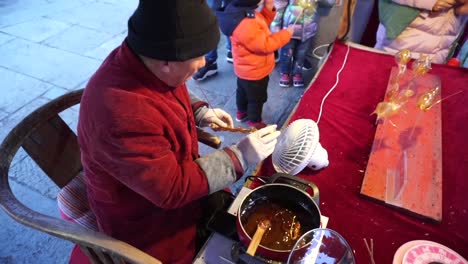 Un-Hombre-Sopla-Dulces-En-Diferentes-Formas-O-Animales-Para-Venderlos-En-El-Mercado-Callejero-De-La-Ciudad-De-Agua-De-Gubei-Antes-Del-Cierre-Oficial-Debido-A-La-Pandemia-De-Covid