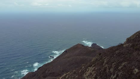 Touristen-Sitzen-Auf-Einem-Felsigen-Gipfel-Im-Ländlichen-Park-Anaga-Mit-Blick-Auf-Den-Atlantischen-Ozean-Auf-Teneriffa,-Kanarische-Inseln,-Spanien
