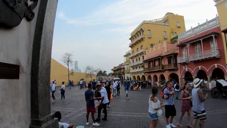 Tourists-standing-and-walking-on-a-plaza-of-the-old-town-of-Cartagena-de-Indias,-Colombia