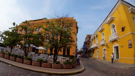 Mehrere-Menschen-Gehen-Auf-Den-Gehwegen-Und-Der-Straße-Der-Altstadt-Von-Cartagena-De-Indias,-Kolumbien