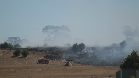 Fire-crew-at-grass-fire-approaching-burnt-grassland
