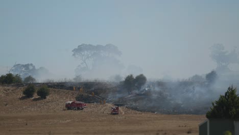 Feuerwehrleute-Bei-Einem-Grasbrand,-Der-Sich-Verbranntem-Grasland-Nähert