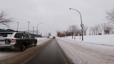 POV-Fährt-Auf-Einer-Vereisten,-Schneebedeckten-Straße-Entlang-Und-Wird-In-Montreal-Von-Einem-Geländewagen-überholt