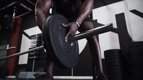 Schwarzer,-Muskulöser-Mann,-Der-In-Einem-Dunklen-Fitnessstudio-Schwere-Gewichte-Auf-Eine-Hantelstange-Legt