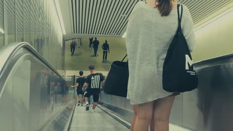 Junge-Frauen-Auf-Einkaufstour-Steigen-In-Der-Stockholmer-U-Bahn-Auf-Eine-Rolltreppe,-Um-Zu-Den-Darunter-Liegenden-Zügen-Hinunterzusteigen
