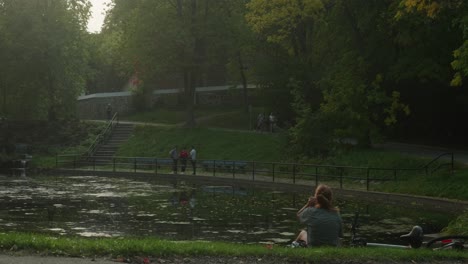 Calm-View-Of-Person-Resting-By-Large-Pond-In-Evening