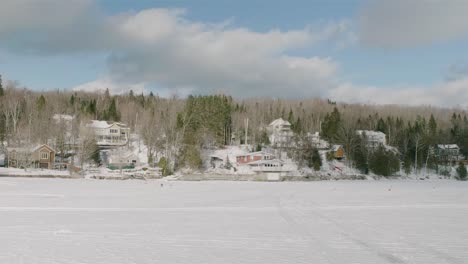 Edificios-Cubiertos-De-Nieve-Vistos-Desde-El-Otro-Lado-Del-Lago-Blanco-Congelado-Megantic-En-Quebec