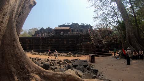 Un-árbol-Enorme,-Ruinas-Establecidas-Para-Marcar-Un-Camino-Y-Un-Templo-En-El-Parque-Arqueológico-De-Angkor