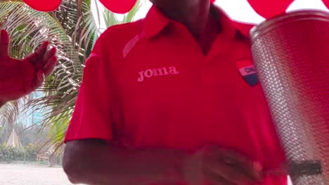 Man-dances-as-he-plays-an-instrument-of-Vallenato-on-a-beach-in-Cartagena-de-Indias,-Colombia