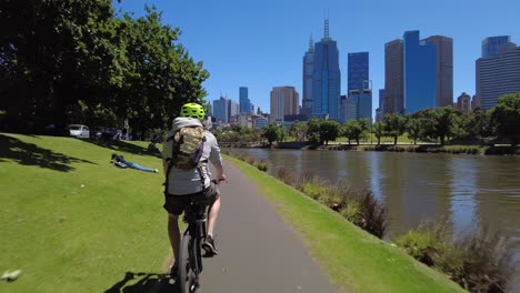 Sie-Folgen-Einem-Radfahrer-Auf-Dem-Flussradweg-Neben-Dem-Fluss