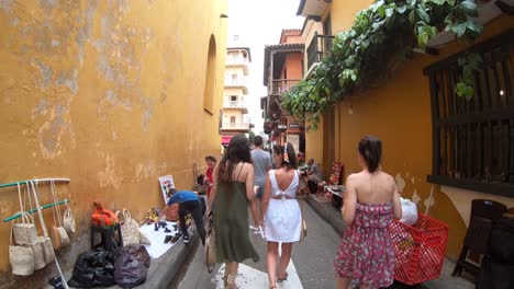 Several-tourists-and-women-are-walking-through-a-street-in-the-old-town-of-Cartagena