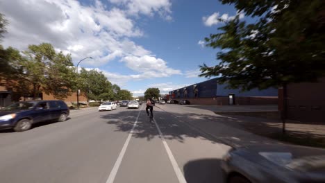 POV-En-Bicicleta-Por-El-Carril-Bici-En-La-Rue-Molson,-Pasando-Por-El-Tráfico-En-Montreal,-Canadá