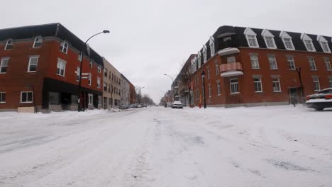 Low-Angle-POV-Travelling-Through-Winter-Snow-Covered-Road-In-Hochelaga-Neighbourhood-During-Winter-In-January-2002
