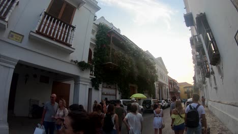 Un-Guía-Sostiene-Un-Paraguas-Amarillo-Mientras-Camina-Y-Guía-A-Su-Grupo-De-Turistas-Por-Las-Calles-Del-Casco-Antiguo-De-Cartagena-De-Indias,-Colombia