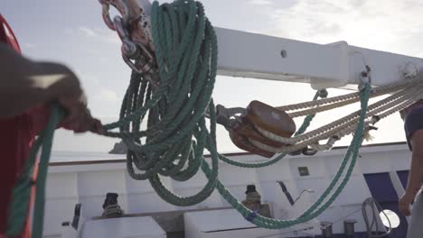 Un-Hombre-O-Marinero-Está-Poniendo-Y-Organizando-La-Cuerda-Verde-Sobre-Una-Grúa-En-La-Cubierta-Delantera-De-Un-Crucero.