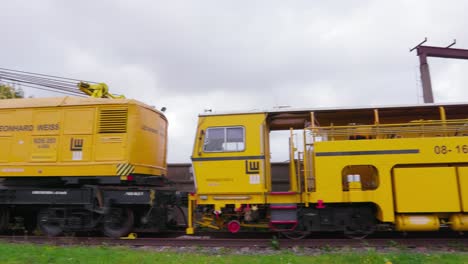 Railway-construction-crane-and-machinery-wagon,-wide-shot,-camera-pan