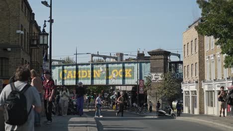 Straßenkunst-An-Der-Camden-Lock-Bridge-Mit-Menschen-Auf-Der-Belebten-Hauptstraße-Tagsüber-In-London,-Großbritannien