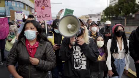 A-woman-is-speaking-through-a-megaphone-to-motivate-the-women-marching-with-her-during-the-International-Women's-day-protest-in-Quito,-Ecuador