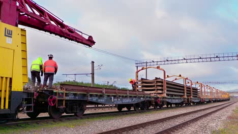 railway-railroad-workers-working-on-a-train-wagon,-wide-shot,-static