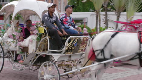 Beautiful-grand-horse-carriage-taking-happy-tourists-on-ride,old-Malacca