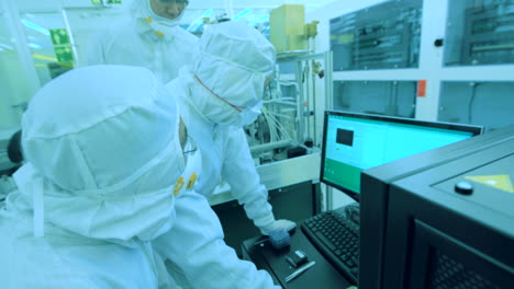 Team-of-scientists-at-work-on-computer-in-blue-illuminated-laboratory