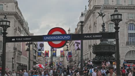Logotipo-Del-Metro-De-Londres-En-Piccadilly-Circus-Con-Gente-En-Westminster,-Inglaterra,-Reino-Unido.