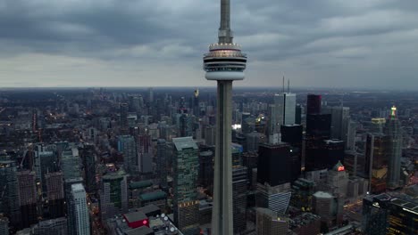 Aerial-view-around-the-CN-Tower-dark-evening-in-Toronto,-Canada---orbit,-drone-shot