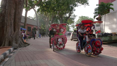 Jinetes-Que-Llevan-A-Los-Turistas-A-Disfrutar-De-Un-Paseo-En-Hermosos-Y-Vibrantes-Trishaws,-Malaca