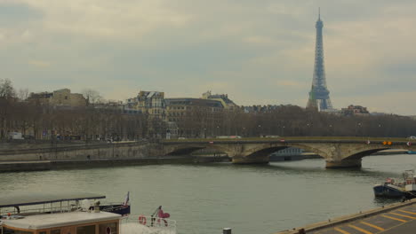 Vista-Panorámica-De-Un-Viejo-Puente-Sobre-El-Río-Sena-Con-La-Torre-Eiffel-Al-Fondo-En-París,-Francia