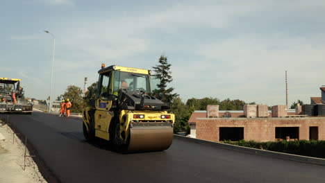 Steamroller-flattening-freshly-asphalted-road-at-construction-site