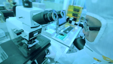 Hoher-Winkel-Des-Wissenschaftlers-Mit-Schutzbrille-Und-Anzug-Am-Mikroskop-Im-Labor
