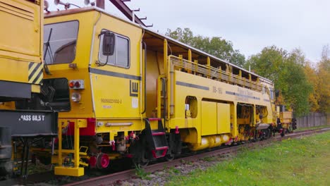 yellow-railway-railroad-construction-train-wagon,-wide-shot,-static