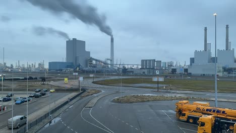Bewegungsunschärfe-Im-Zeitraffer-Des-Verkehrs-Mit-Rauch,-Der-Aus-Dem-Schornstein-In-Maasvlakte-An-Einem-Bewölkten-Tag-In-Rotterdam,-Niederlande,-Austritt