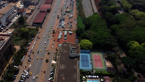 Aerial-view-following-traffic-in-downtown-Yaounde,-sunny-day-in-Cameroon,-Africa