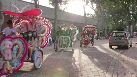 Turistas-Disfrutando-De-Un-Paseo-En-Hermosos-Trishaws-Decorados-Y-Vibrantes,-Malaca