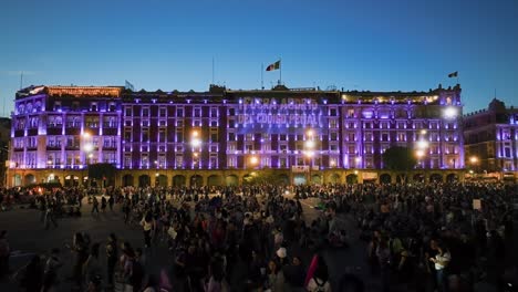 Vista-Aérea-De-Personas-Que-Protestaban-Frente-A-Un-Edificio-Iluminado-En-La-Ciudad-De-México---Reversa,-Disparo-De-Drones