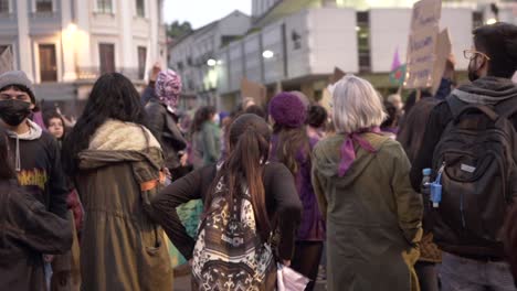 A-group-of-women-is-standing-and-waiting-for-the-march-to-begin-during-the-International-Women's-day-in-Quito,-Ecuador,-They-are-wearing-masks-due-to-covid-19